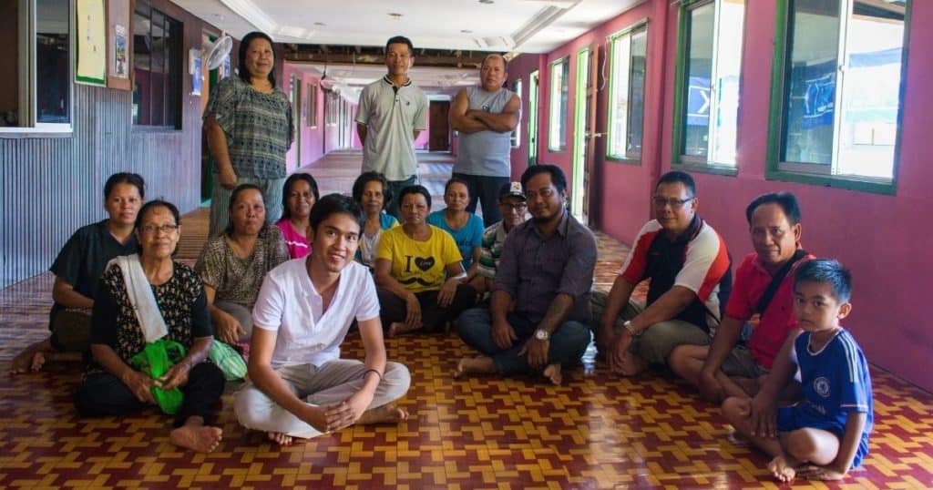 Albert with his community and the film protagonist, Tony (in striped purple shirt) in his community's longhouse